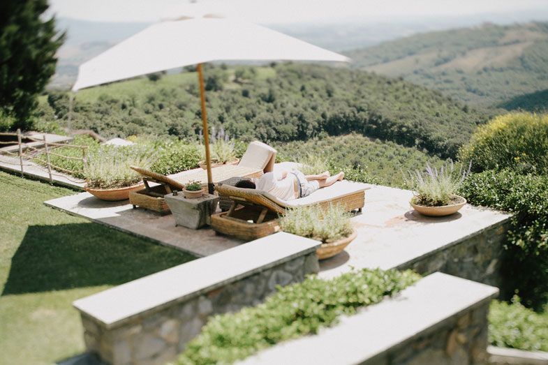 Outdoor dining setup with white tables and benches overlooking a scenic mountain landscape.