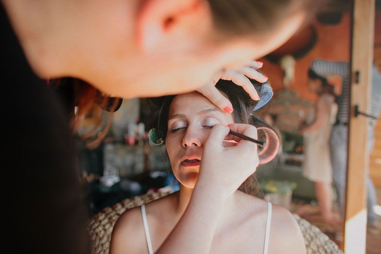 Makeup artist carefully applies cosmetics to create a bridal look in preparation for a wedding ceremony.