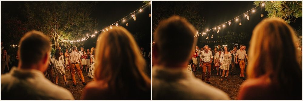 Warm evening celebration scene with string lights and crowd beneath dark sky.