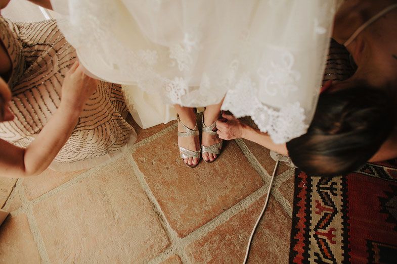 Close-up shot of bare feet on terracotta tiles with white dress fabric flowing around.