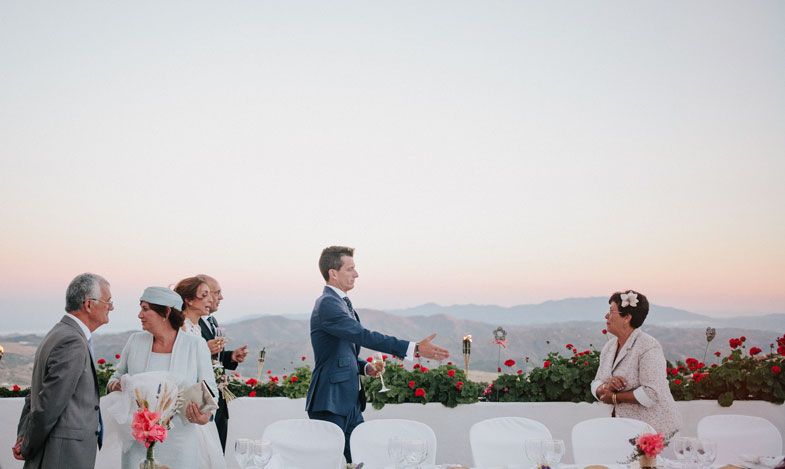 Wedding celebration on a Mediterranean terrace with mountains visible in the distance.