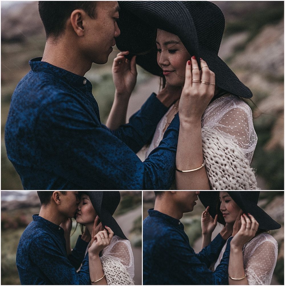 Romantic couple sharing an intimate moment outdoors wearing blue and white lace in a moody natural setting.
