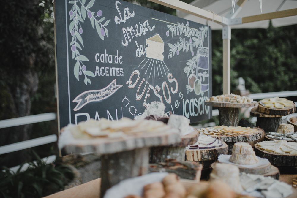 Wedding dessert display with chalkboard menu and tiered cake stands.