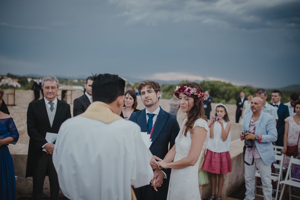 An outdoor wedding ceremony with guests seated and a couple standing at the altar.