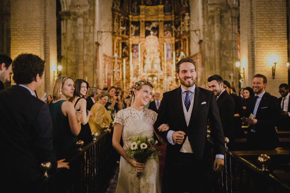 Elegant church wedding ceremony with couple at altar surrounded by guests and ornate decor.