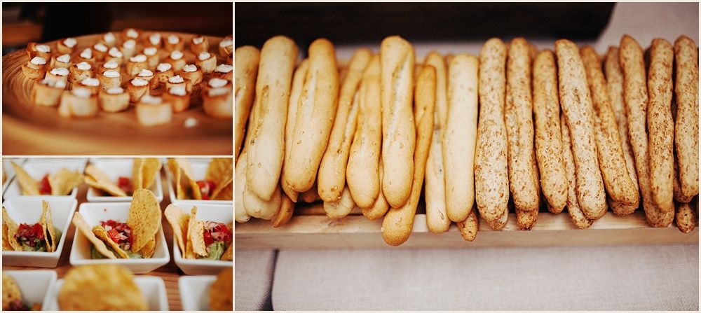 Wedding reception food display featuring breadsticks and appetizers on platters.
