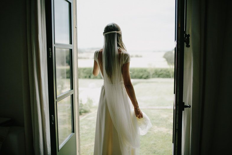 A silhouette of someone in a flowing white dress standing in an open doorway.