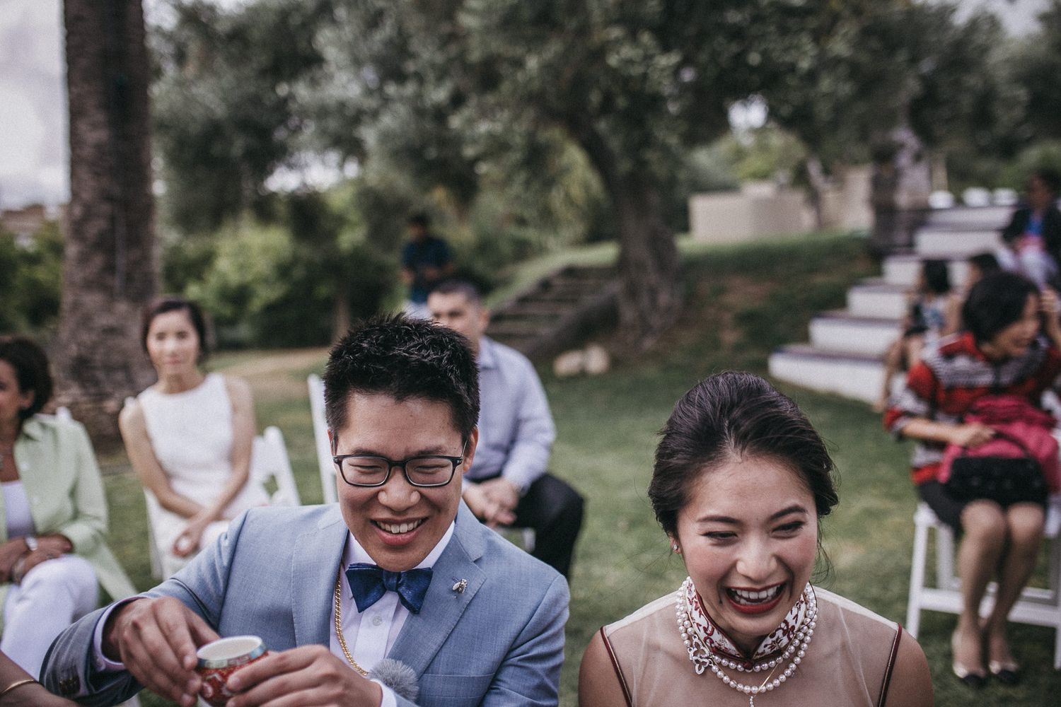 Wedding guests enjoying outdoor celebration in park setting.