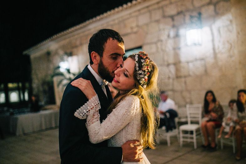 Romantic dance moment at an outdoor wedding reception with string lights.
