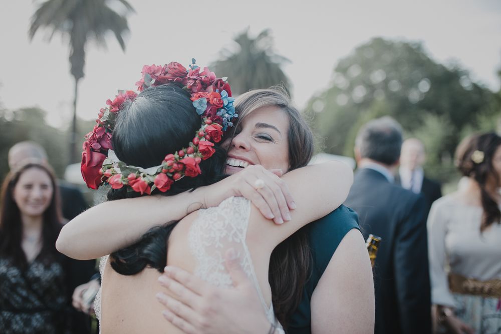 An emotional embrace during a wedding celebration with palm trees in the background.