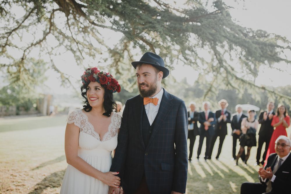 An outdoor wedding ceremony with guests gathered under a majestic tree.