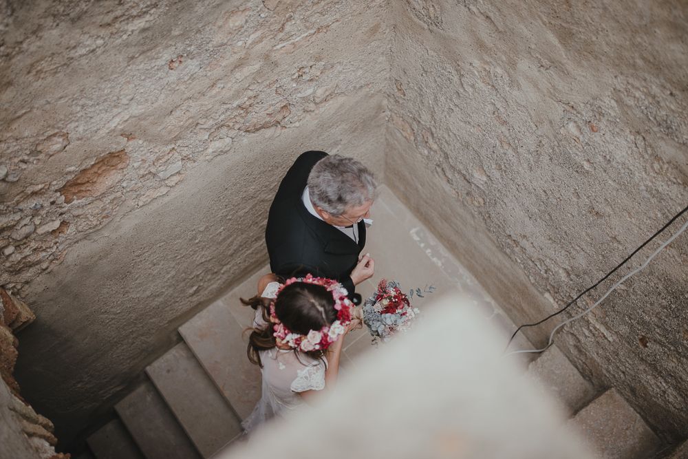 Overhead view of someone descending stone stairs in an ancient building.