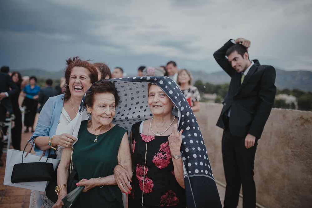 Wedding guests watching the ceremony on a rooftop venue with mountains visible.
