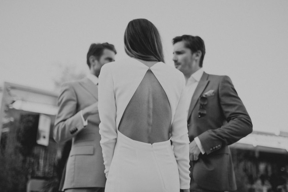 Black and white photo of guests conversing at an elegant outdoor event.