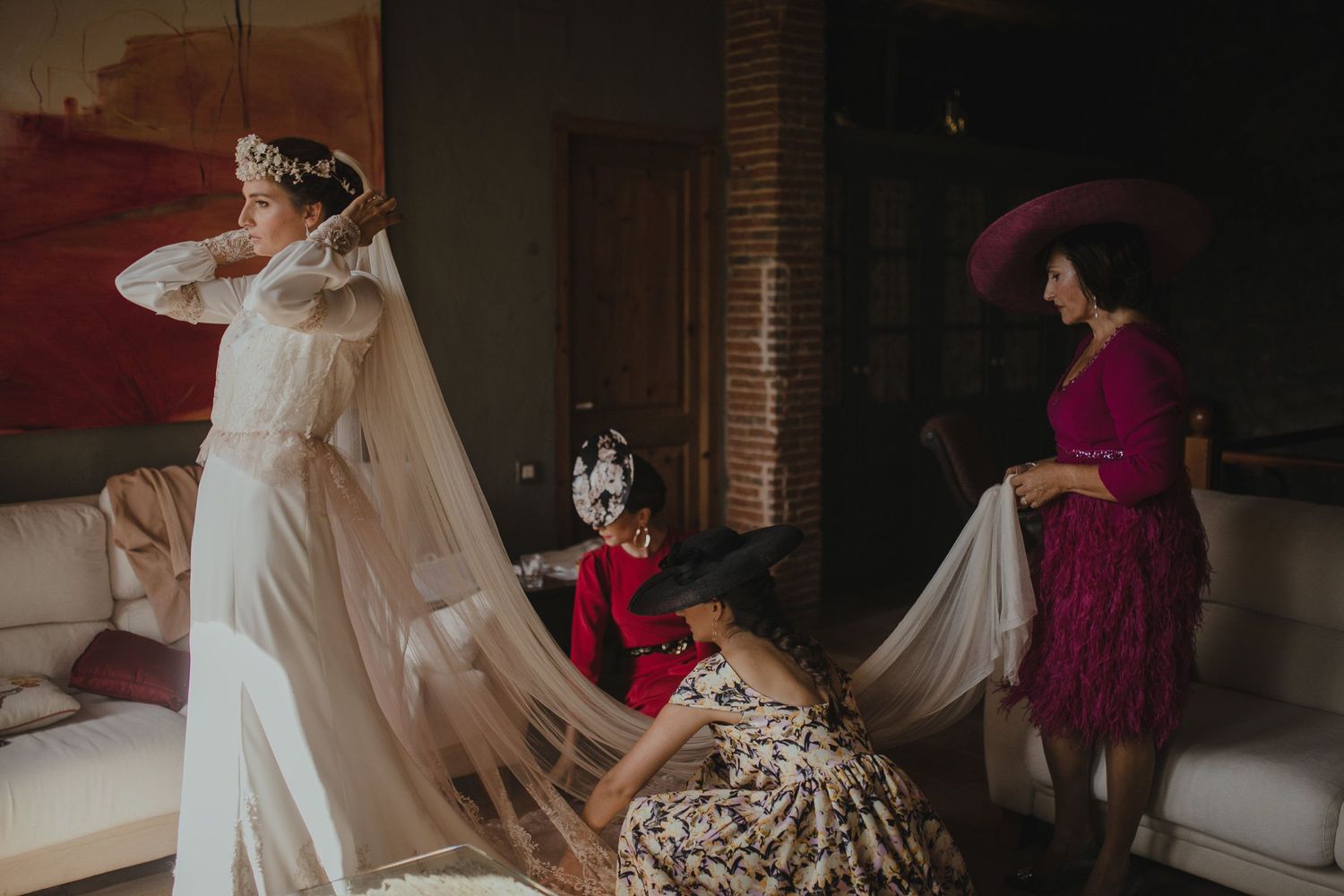 Wedding preparations show dress adjustments with attendants in floral and fuchsia attire.