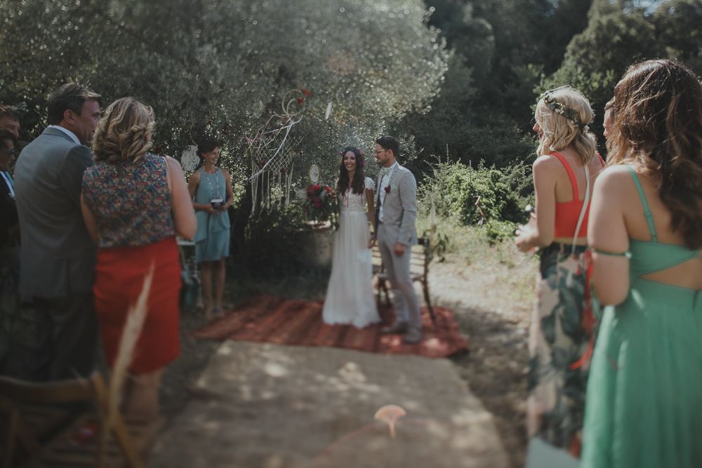 Wedding ceremony processional on a garden path with guests watching.