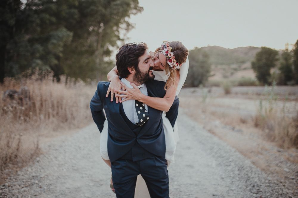 Romantic couple sharing a playful moment on a rural dirt path.
