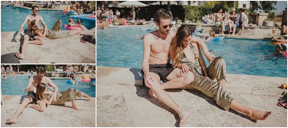 People relaxing by a resort swimming pool on a sunny day.