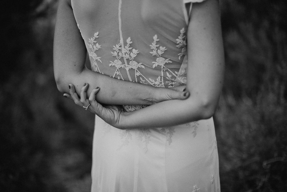 Close-up of delicate embroidered details on a white wedding dress.