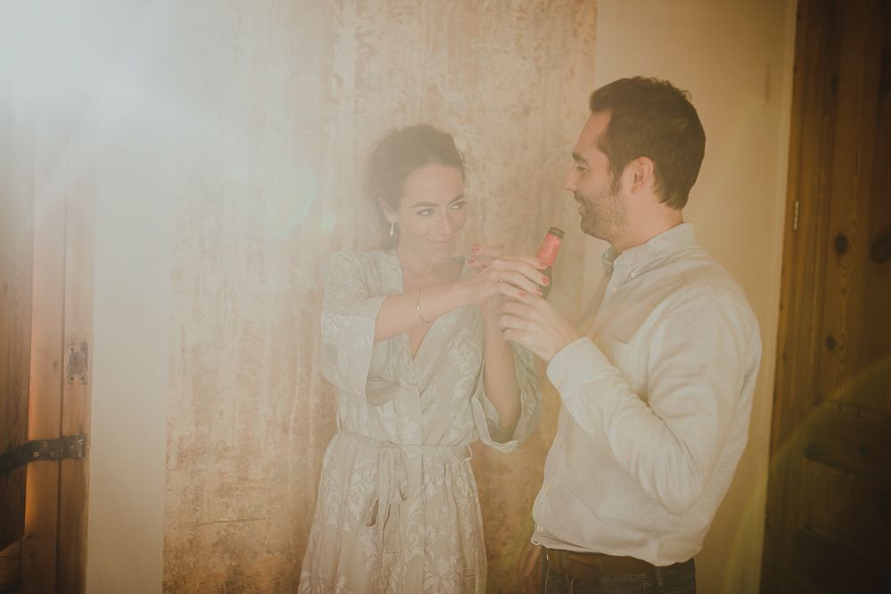 A couple shares a tender moment while getting dressed in formal attire.