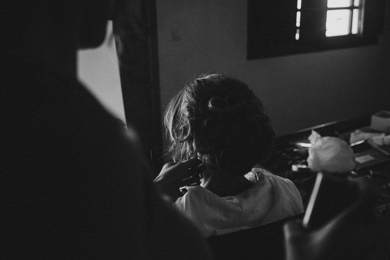 Silhouette of person getting ready in dark room with window light.