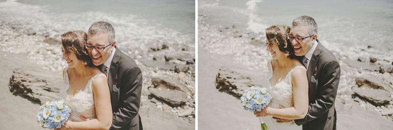 A romantic moment captured between a couple by rocky coastal scenery.