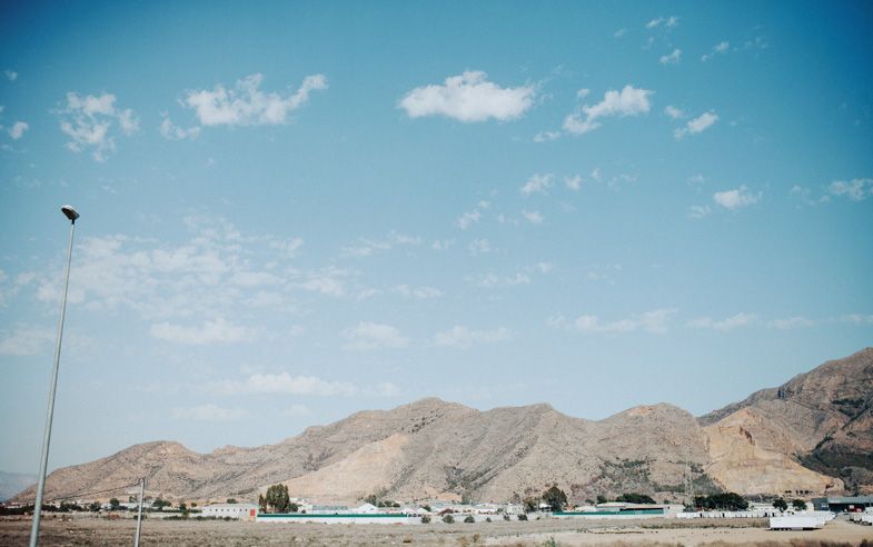 Desert landscape with mountains and blue sky in the background.