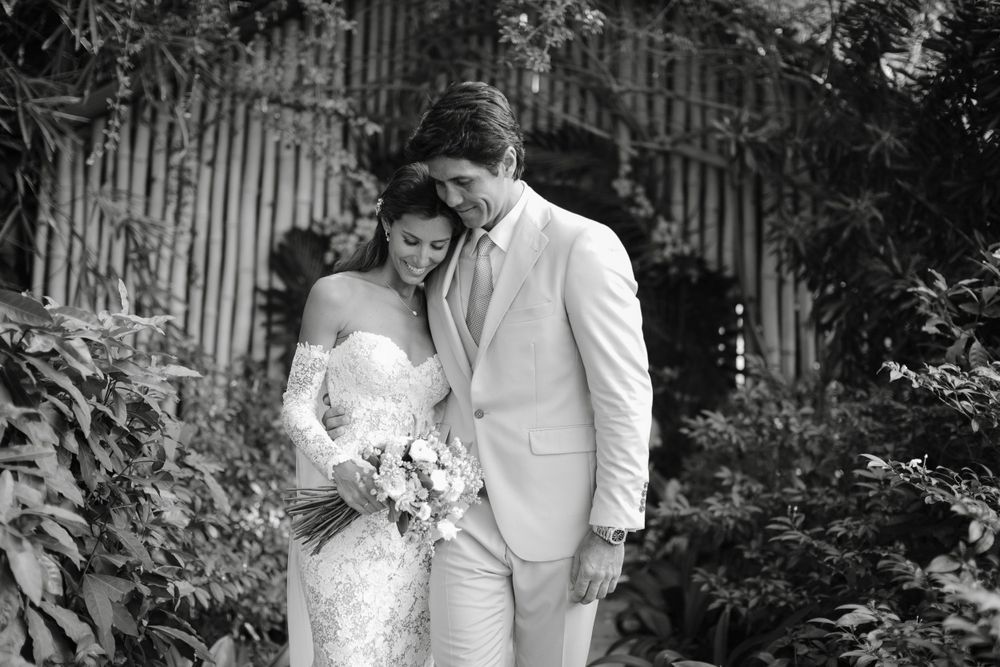 Romantic black and white portrait of couple among garden foliage.