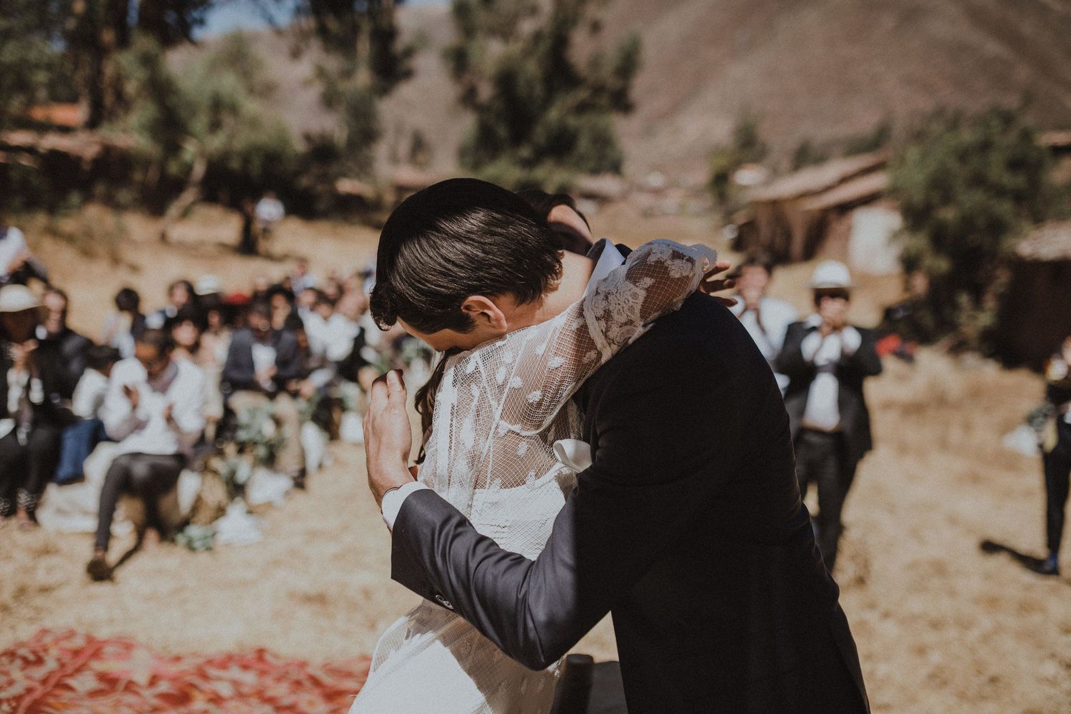 A passionate embrace between newlyweds during their outdoor wedding celebration.