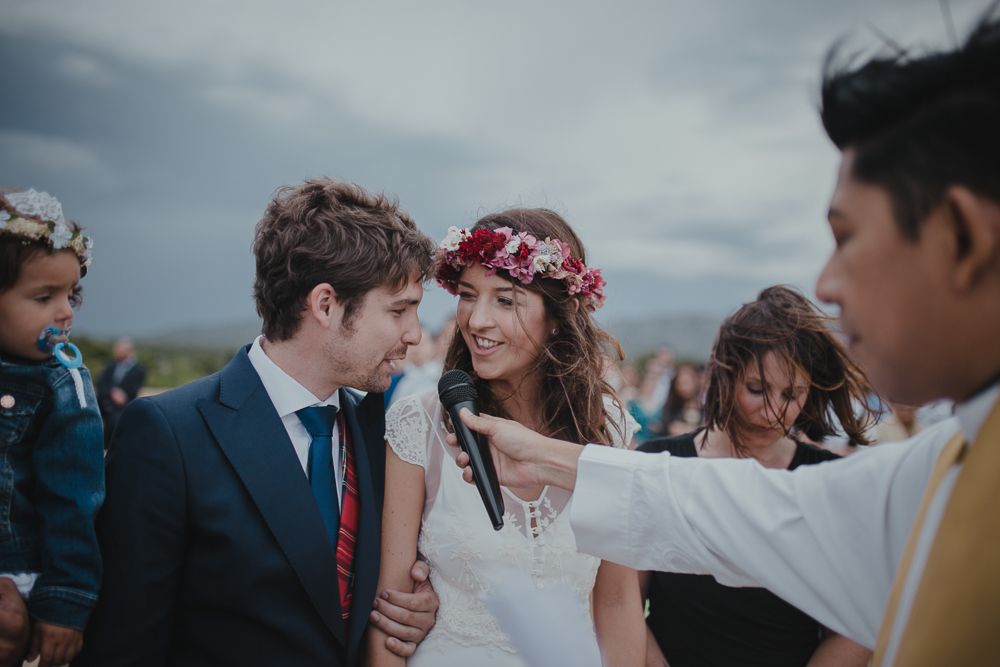 Wedding ceremony participants interact during an intimate rooftop celebration.