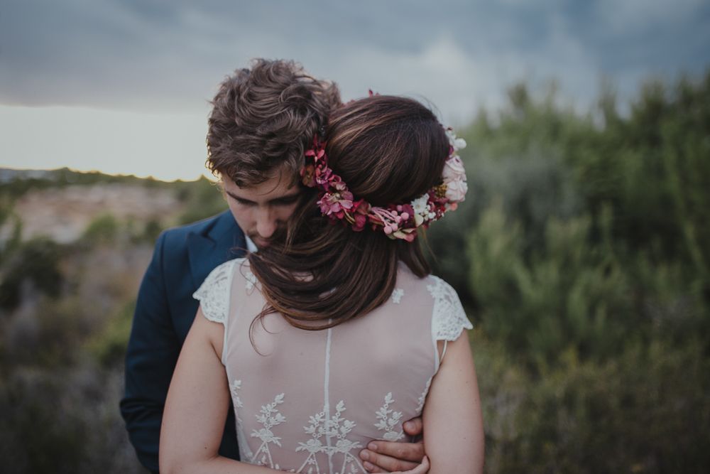 A close-up wedding portrait showcasing the bride's floral crown and dress details.
