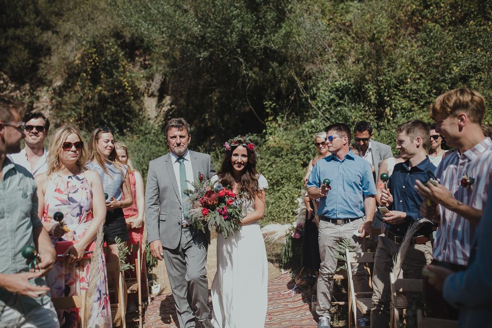 Wedding ceremony with wedding party and guests gathered on an outdoor path.