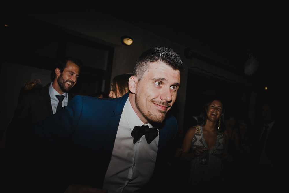 Formal event attendee in black bow tie photographed against dark background.