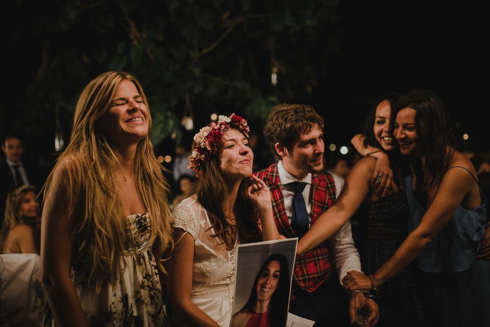 Wedding celebration with guests enjoying a joyful moment under evening lights.
