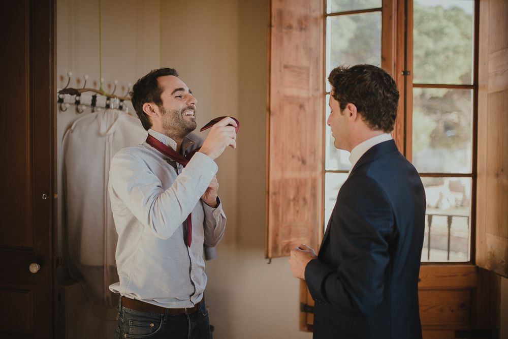 Two people having animated conversation in formal attire indoors.
