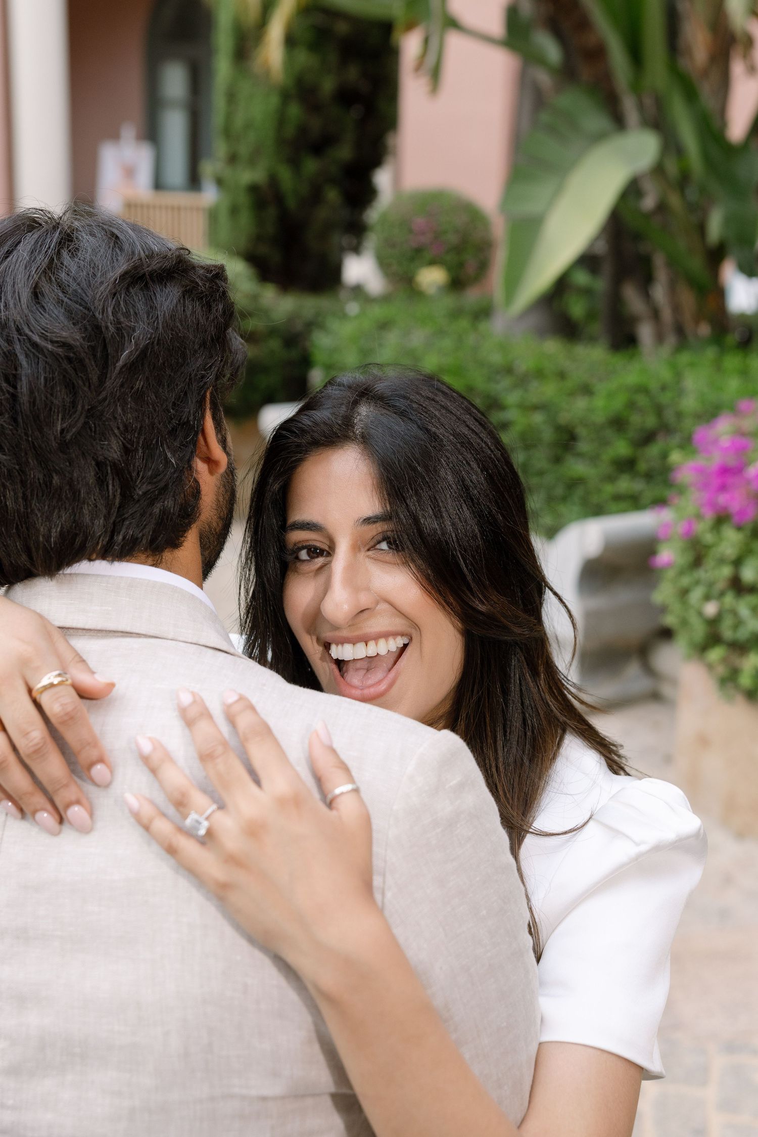 Elina laughing as she embraces Jag, with her engagement ring visible.