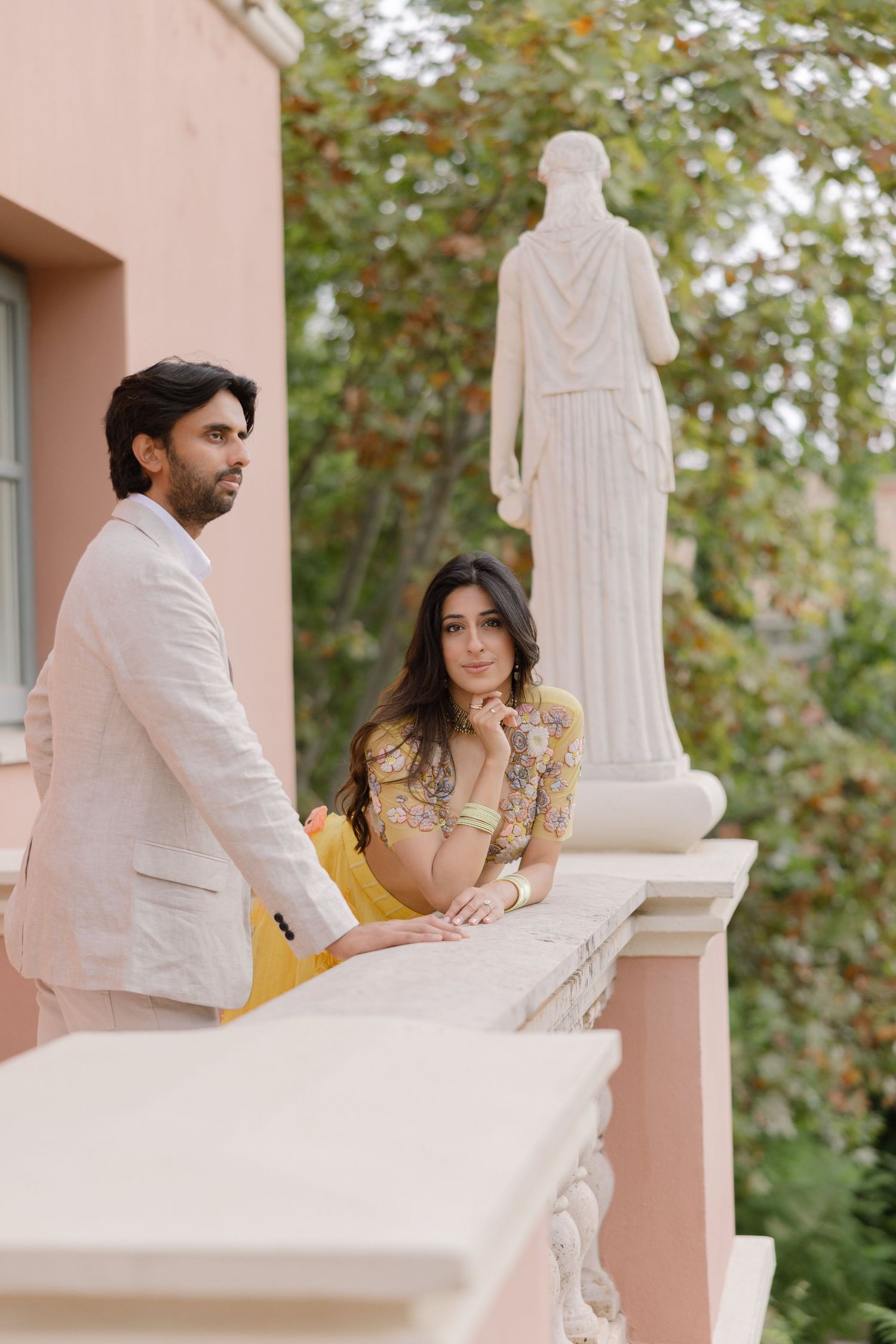 Elina and Jag beside a marble balustrade, with Elina wearing yellow.