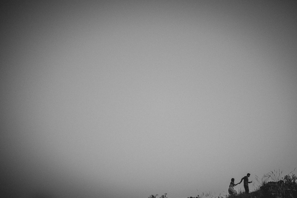 Minimalist silhouette of two people standing together against a gradient sky.