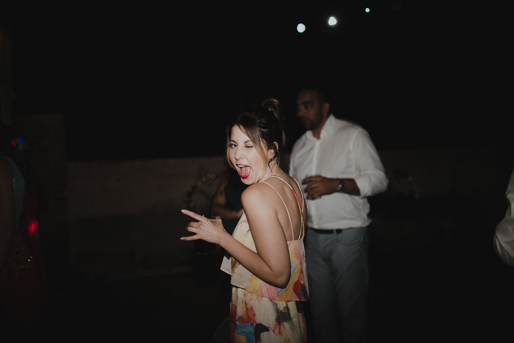 Wedding celebration on dance floor with bride in white dress wearing floral crown.