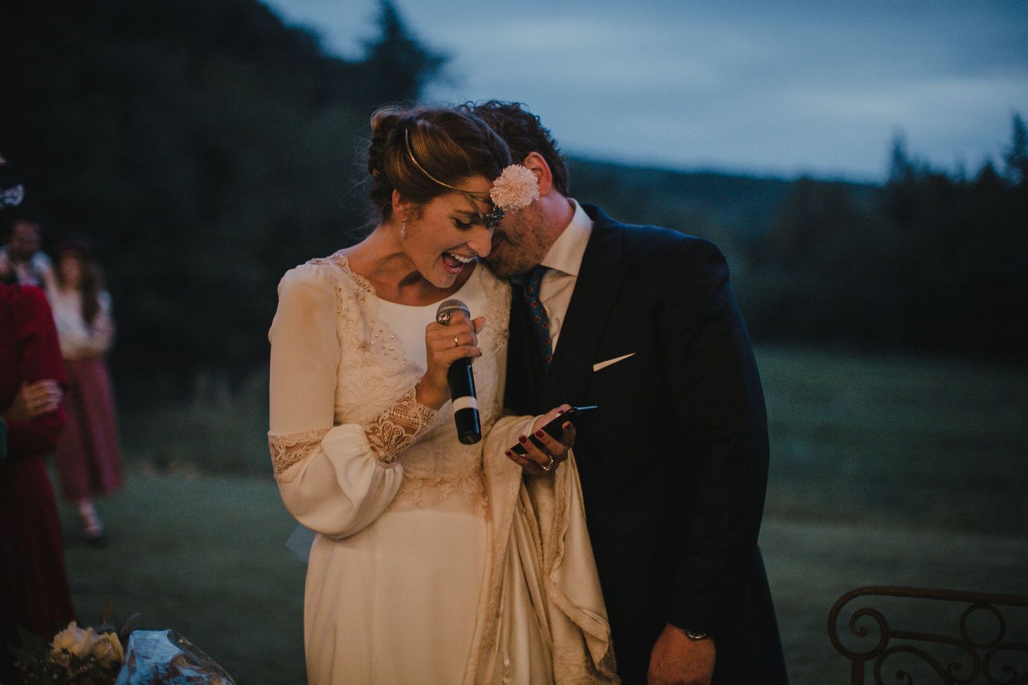 Intimate moment as couple shares readings during twilight outdoor ceremony.