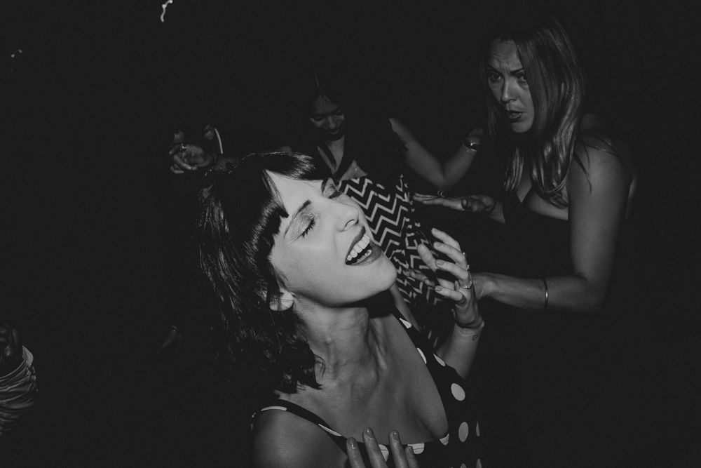 Party-goers dance and celebrate in an energetic black and white nightlife scene.