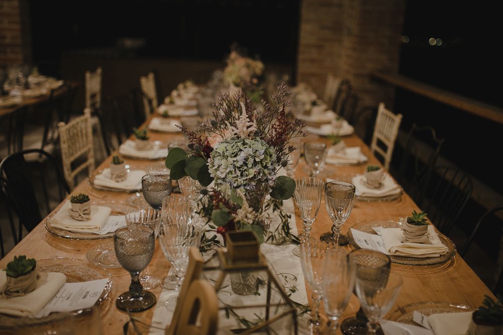 Elegantly set dining table with crystal glasses and floral centerpiece for special event.
