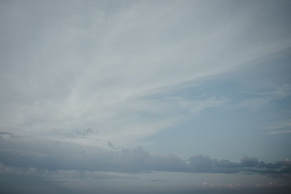 Dramatic cloudy sky with soft blue tones creates a moody backdrop.