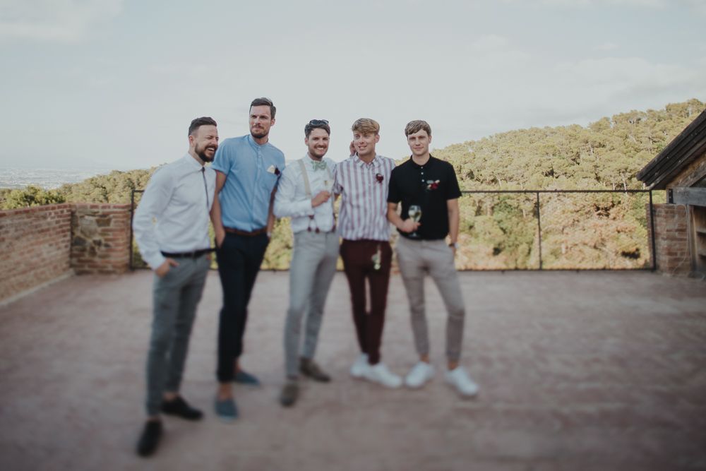 A group of people standing together on an outdoor patio with desert mountains in the background.