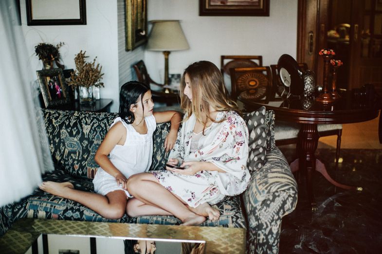 Two people sharing a moment while taking photos on vintage furniture.