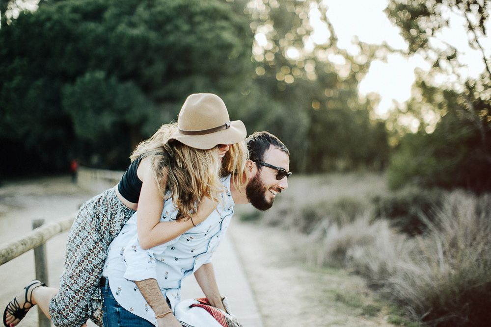 A playful piggyback ride along a nature trail at sunset.
