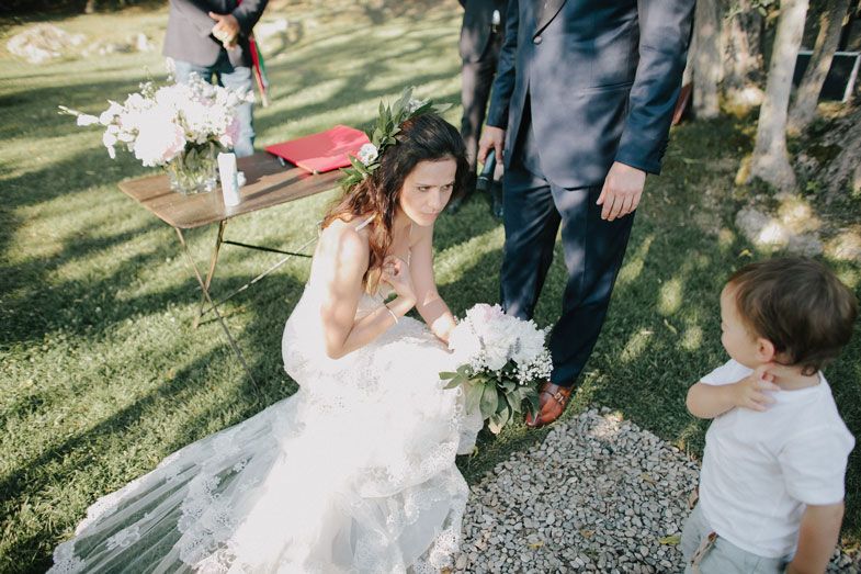 A romantic first dance moment between newlyweds in a sun-dappled garden setting.