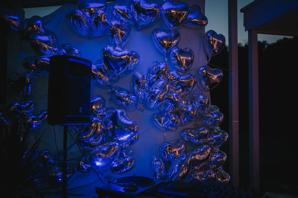 Abstract blue glass art installation with curved shapes illuminated against dark background.
