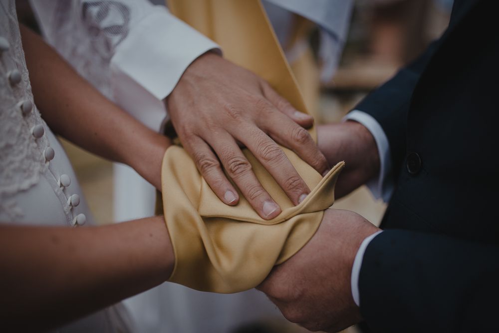 Close-up of hands holding a small cloth bag during a wedding ceremony.