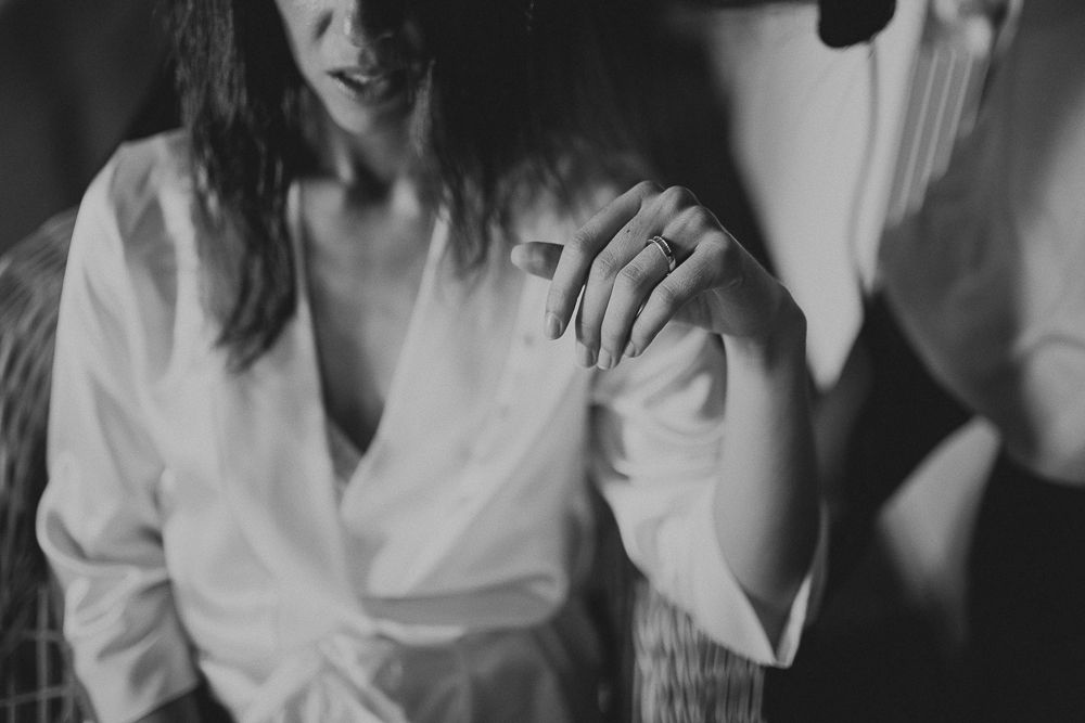 A black and white artistic shot showing hands clasped together in an intimate moment.
